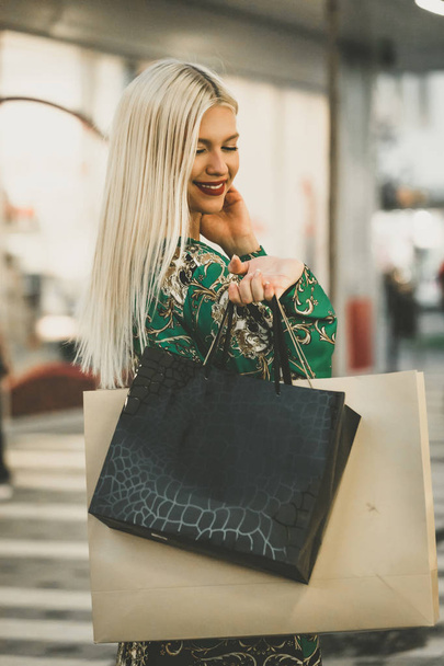 Ευτυχισμένη γυναίκα με τσάντες ψώνια απολαμβάνοντας τα ψώνια - Φωτογραφία, εικόνα