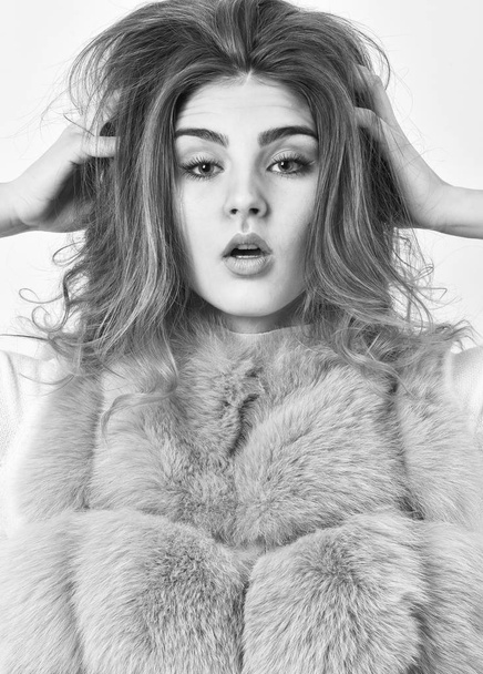 Prevent winter hair damage. Woman makeup face touch hair volume hairstyle. Girl fur coat posing with hairstyle on white background. Winter hair care tips you should follow. Hair care concept - Foto, Imagen