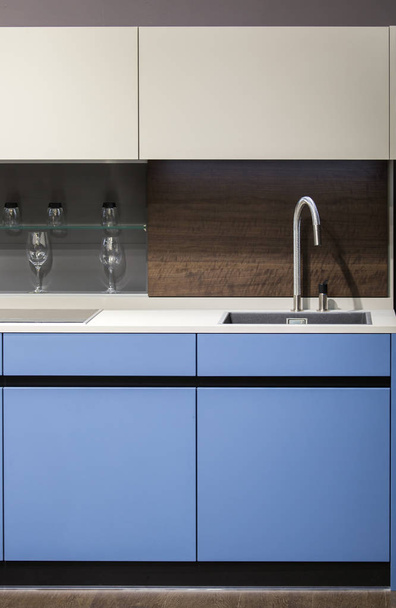 Beautiful blue kitchen unit, kitchen faucet, wooden apron in the kitchen. Modern minimalistic kitchen design - Foto, immagini