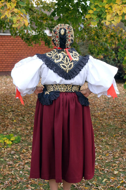 Γυναίκα ντυμένη με λαϊκές στολές πάει στην εκκλησία στη λειτουργία την ημέρα των Ευχαριστιών στο Στίταρ της Κροατίας - Φωτογραφία, εικόνα