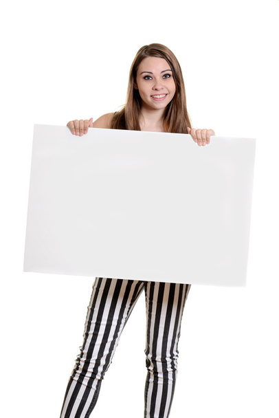 Teen girl with stripe pants holding blank sign - Foto, afbeelding