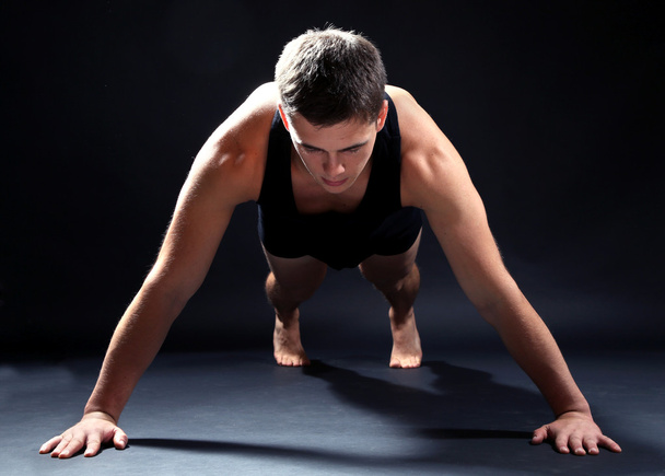 Handsome young muscular sportsman, on dark background - Foto, Imagen