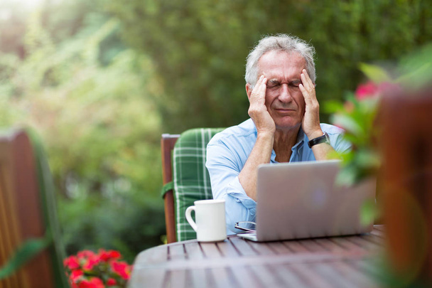 Senior man looking stressed while working on laptop  - Foto, Bild