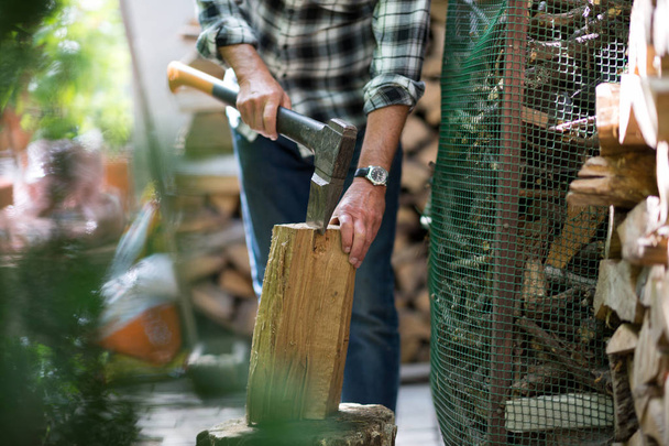 Senior Mann beim Baumstammschneiden, Arbeiten im Garten (Schwerpunkt Axt)) - Foto, Bild