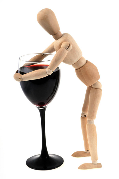 Цей дерев'яний маннекін тримає склянку червоного вина на білому тлі
  - Фото, зображення