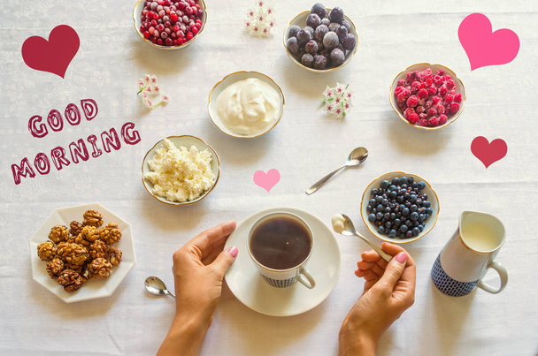 GOOD MORNING text and hearts on a flat lay table with berries, female hands and coffee - Foto, afbeelding