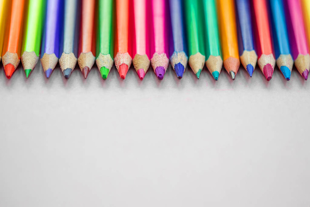 Colored pencils in a  row on a grey background. Back to school c - 写真・画像