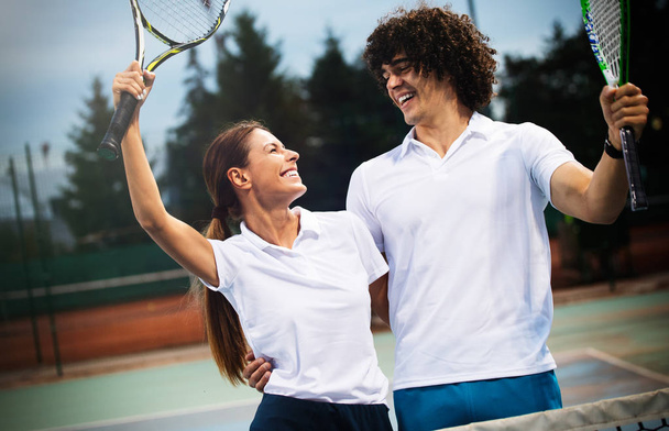 Happy fit people playing tennis together. Sport concept - Foto, Imagen