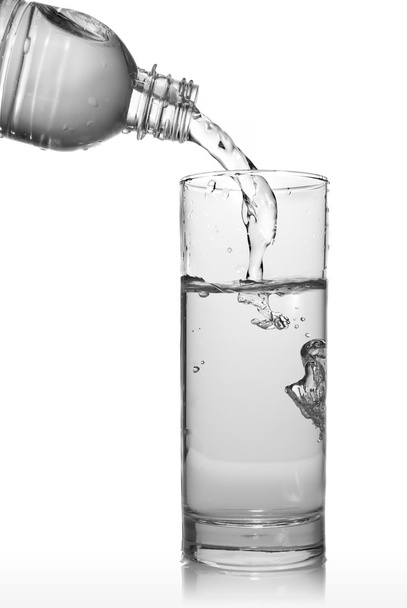 νερό ρίχνει σε ποτήρι από το μπουκάλι - Φωτογραφία, εικόνα