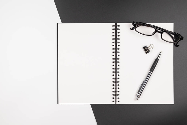 Vista superior de um caderno com caneta sobre fundo preto e branco
 - Foto, Imagem