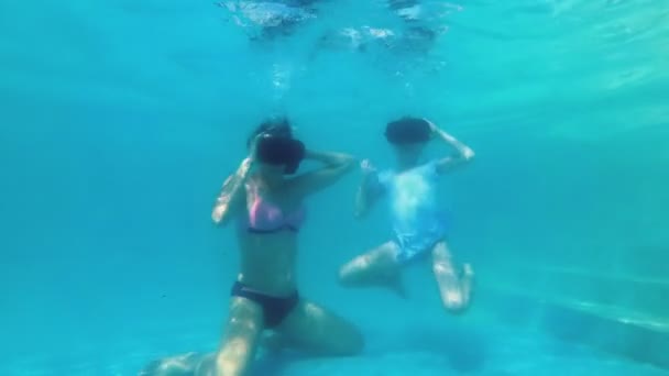 Mom and little daughter together dive under the water in virtual reality glasses. They play virtual games underwater in the pool and blow bubbles. Slow motion. Concept video. 4K. - Video, Çekim