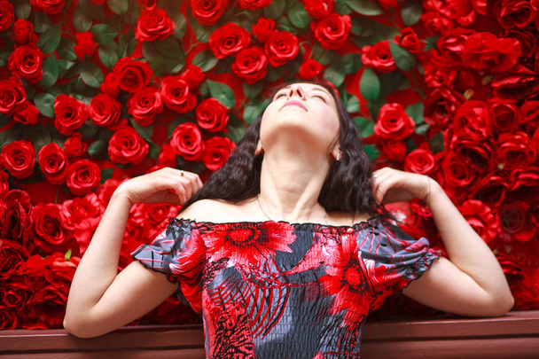 Portrait of elegant dreamy woman in dress on red roses - Fotoğraf, Görsel