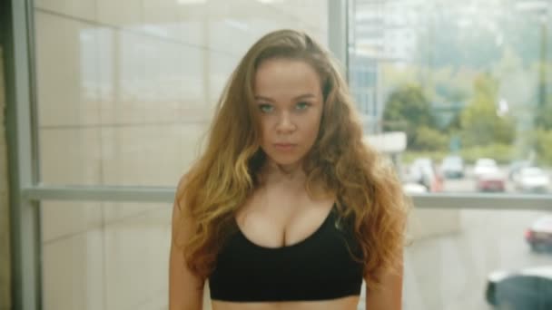A woman with curly hair in sports bra panting - Filmagem, Vídeo