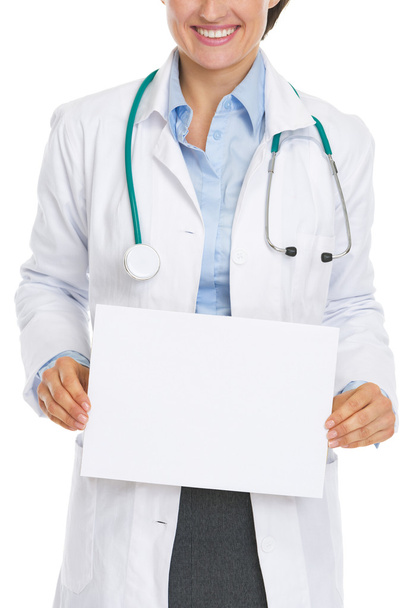 Primo piano sulla donna medico sorridente mostrando foglio di carta bianco
 - Foto, immagini