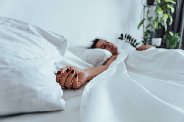 mulher dormindo na cama mão fechar o foco seletivo
 - Foto, Imagem