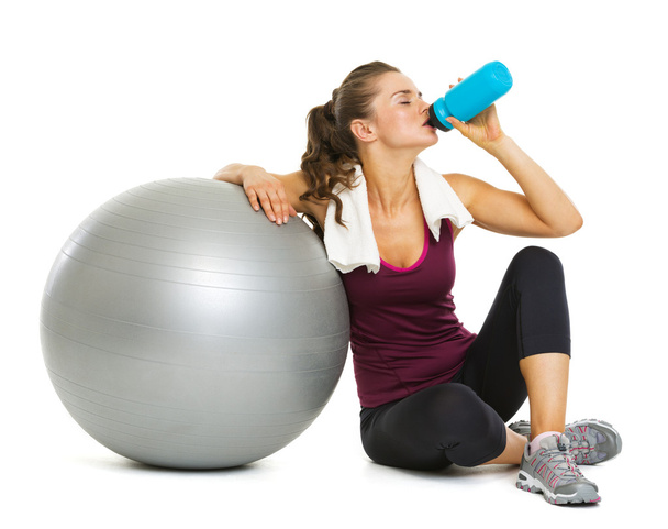 Fitness young woman with fitness ball drinking water - Foto, Bild