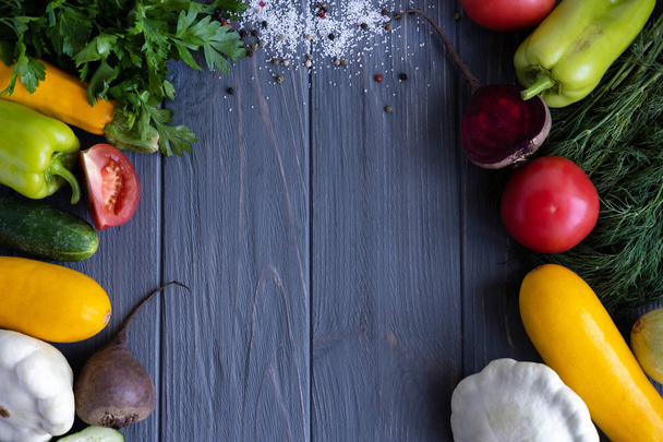 Zelenina na tmavém pozadí po stranách s místem pro nápis. Rámeček pro text. Rajčata, okurky, petržel, papriky, dýně - Fotografie, Obrázek
