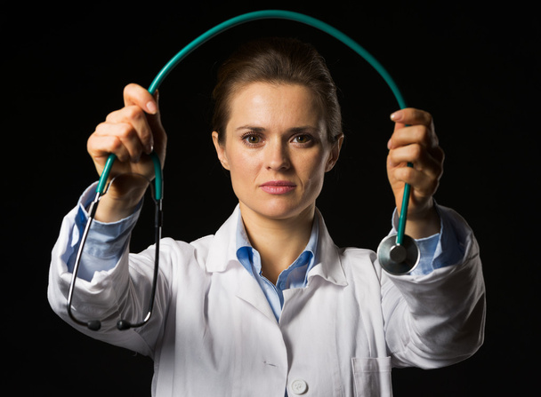 Doctor woman giving stethoscope isolated on black - Фото, изображение