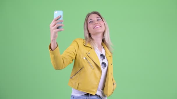 Happy young rebellious blonde woman taking selfie - Video, Çekim
