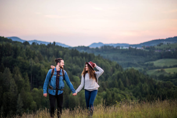Young tourist couple travellers with backpacks hiking in nature. - Foto, immagini