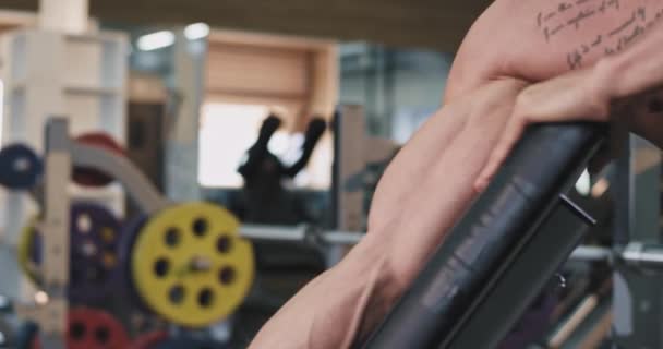 Details bodybuilding man doing exercises in a large spacious gym portrait baked biceps workout lifting up the dumbbell - Felvétel, videó