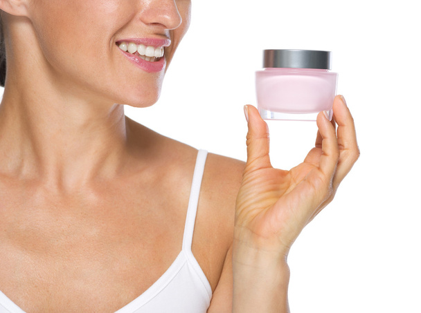 Closeup on young woman looking on cream bottle - Foto, imagen