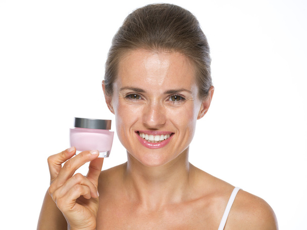 Smiling young woman holding cream bottle - Foto, imagen