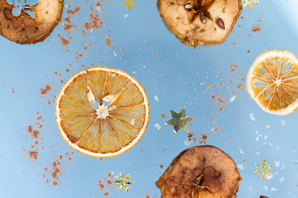 Ginger cookies with dry apple and oranges slices and cinnamon stick are flying on a blue background. Food levitation. Christmas concept - Foto, Bild