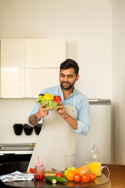 Handsome young man standing in the kitchen at home - Photo, Image