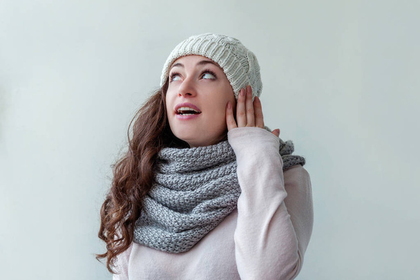 Смеющаяся девушка в теплой одежде шляпа и шарф на белом фоне
 - Фото, изображение