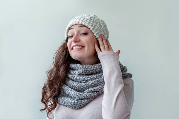 lachendes Mädchen mit warmer Mütze und Schal auf weißem Hintergrund - Foto, Bild