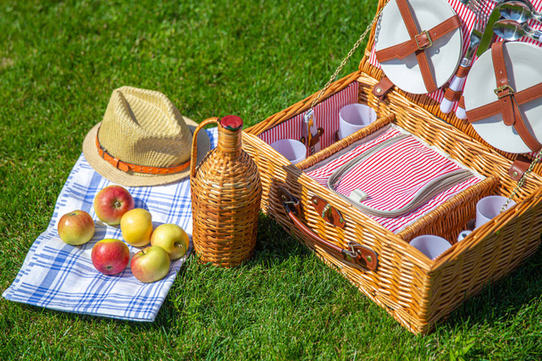 Cesta de picnic en césped verde soleado en el parque
 - Foto, Imagen