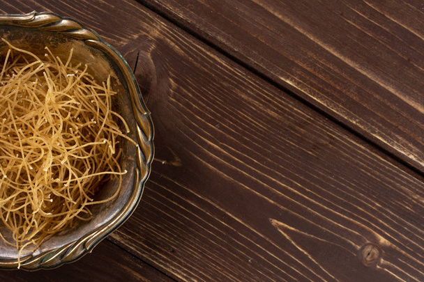 Raw thin noodles on brown wood - Foto, Bild