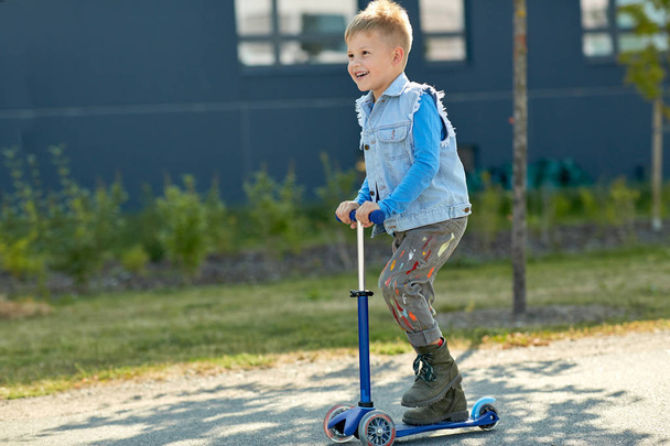 niño feliz montar scooter en la ciudad - Foto, Imagen