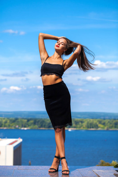 Portrait of a young beautiful girl in a black skirt and a bra po - Photo, image