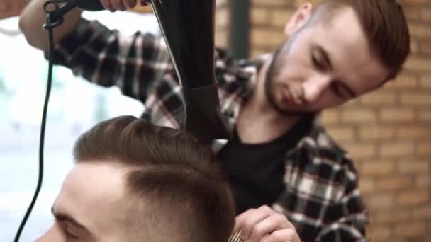 Close up on Mens hairstyling and haircutting in a barber shop or hair salon using scissors and hair dryer. Grooming the hair. Barbershop. - Video
