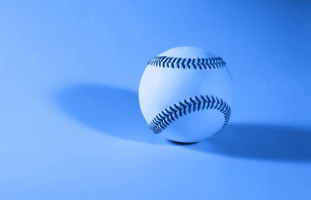 бейсбол на синьому кольоровому фоні і червоний зшитий бейсбол
.  - Фото, зображення