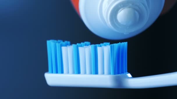 Zahngesundheit - weiße Zahnpasta aus einer Tube auf eine Zahnbürste drücken. - Filmmaterial, Video