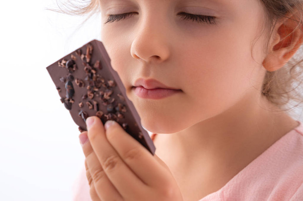 Krásná dívka chutná čokoládu jako prolámání kakaa - Fotografie, Obrázek