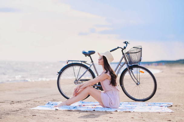 海辺で彼女の自転車で美しいブルネットの肖像画 - 写真・画像