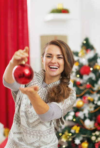 Happy young woman showing christmas ball - Φωτογραφία, εικόνα