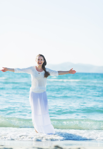 Happy young woman rejoicing on sea shore - 写真・画像