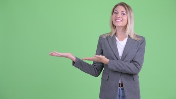 Boldog fiatal gyönyörű szőke üzletasszony mutatja valamit - Felvétel, videó