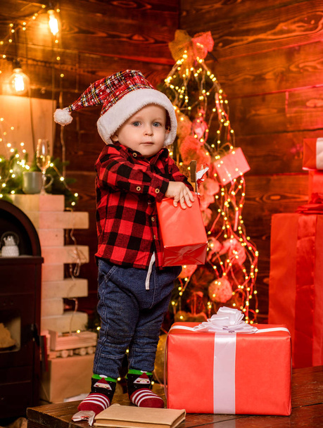 Open gift. Lovely baby enjoy christmas. Santa boy little child celebrate christmas at home. Childhood memories. Boy cute child cheerful mood christmas gift. What is inside. Merry and bright christmas - Фото, зображення