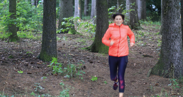 Młoda kobieta podczas treningu w lesie. Jogging zdrowie. Dziewczyna wygłosi zdrowie styl życia. Płytkie DOF. - Materiał filmowy, wideo