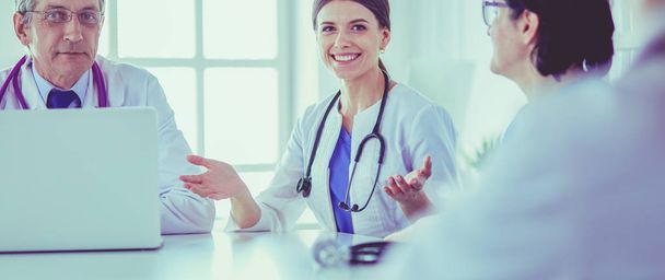 Serious medical team discussing patients case in a bright office - 写真・画像