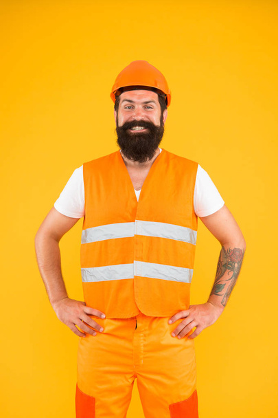 Labor day. Safety apparel for construction industry. Bearded brutal hipster safety engineer. Man engineer protective uniform orange background. Engineering career concept. Architect builder engineer - 写真・画像