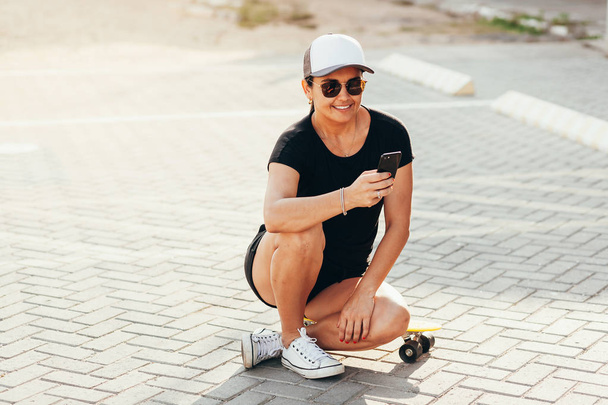Portrait of beautiful woman with skateboard in the city. - Φωτογραφία, εικόνα