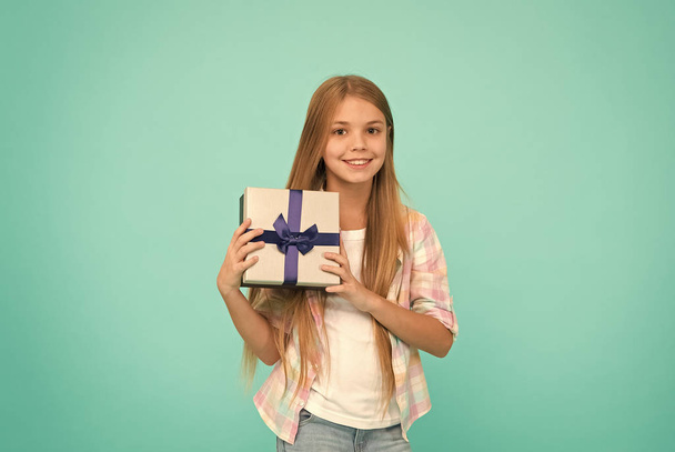 Making gift with soul. Little shopaholic with present wrapped in box. Small child holding gift box tied with ribbon bow. Small girl after shopping for gift. Cute shopper enjoy doing a little shopping - Fotó, kép