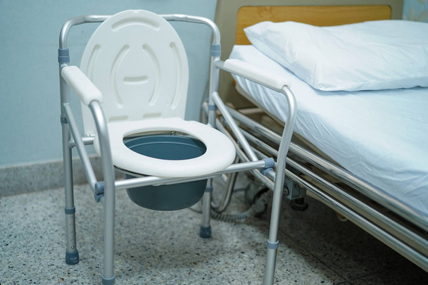 Chaise commode ou toilettes mobiles peuvent se déplacer dans la chambre à coucher ou partout pour les personnes âgées handicapées ou le patient : concept médical fort sain
  - Photo, image